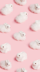 Pattern with white fluffy bunnies on pastel pink background. Minimal Easter holiday animal concept....