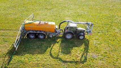 Großer Traktor mit Gülletonne düngt Wiese, industrielle Landwirtschaft aus der Vogelperspektive © keBu.Medien