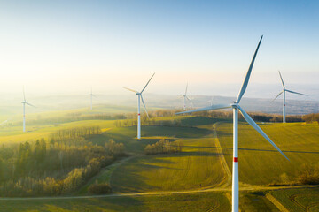 Panoramic view of wind farm or wind park, with high wind turbines for generation electricity with...