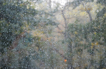 window glass with many drops of water after the last rain, cloudy weather outside the window