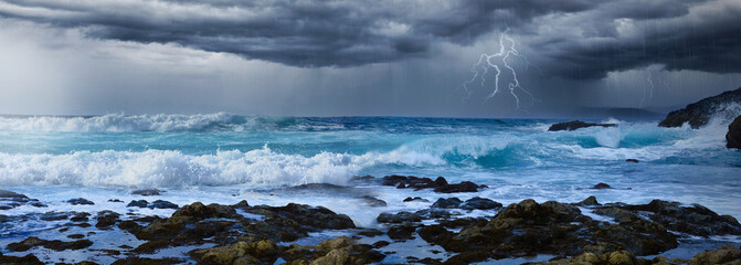 Stormy weather over the night sea coast line with lightning flash and thunder storm and big waves....