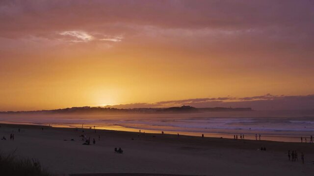 atardecer en la playa de santander con gente en calma
