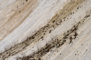 Geological cross-section of the soil. View of the sand mountain and various layers of soil. Sand quarry. Extraction of sand and stones.