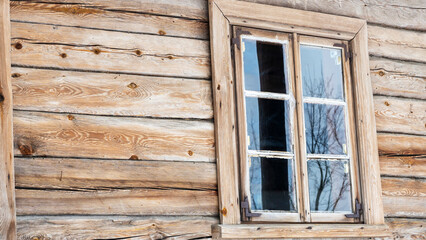 Fototapeta na wymiar Boarded up windows on the old wooden wall of the house. Carving adorns the old window. Image for design. Countryside concept.