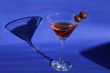 cocktail with olives and blue background