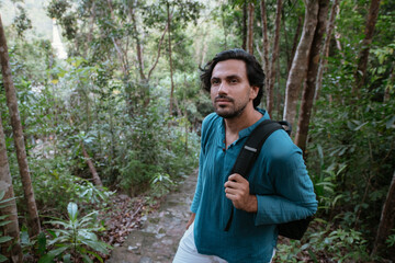 Male tourist climbs up the mountain in the tropical forest.