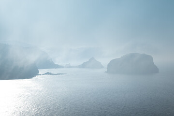 Fototapeta na wymiar Gaztelugatxe from Machichaco Cape on a foggy day, Basque Country in Spain