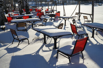 Benches covered with snow on a bright sunny day

