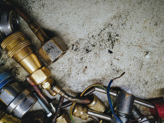 Locksmith and plumbing parts, tools and spare parts in the form of brass, copper and metal pipes, bushings, adapters, nuts and wrenches. Refrigeration repair technician concept, copy of space.