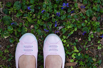 piedi con scarpe rosa sull'erba verde viste dall'alto