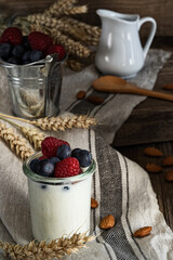 Delicious naturall Yogurt And Fresh Berries For Breakfast on a rustic  wooden background.