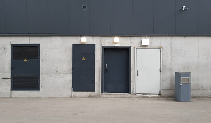 Obraz na płótnie Canvas three doors on a concrete wall, technical or fire exit, loading area, building facade