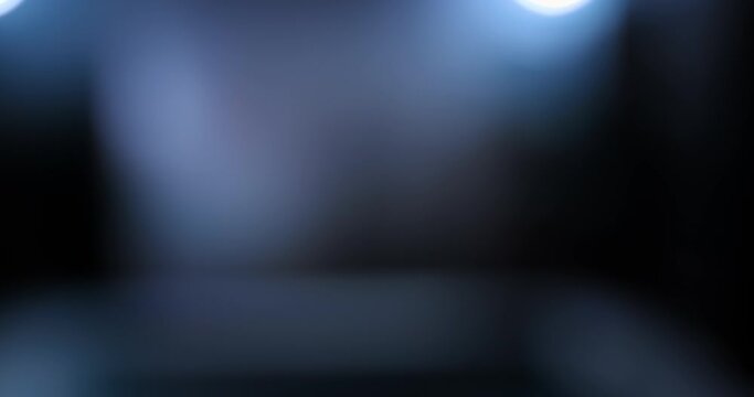 Male boxer walks out of the fog into a dark gym and stands on the tatami. Boxer enters the gym for training, punching bags hang in a row. 4k, ProRes