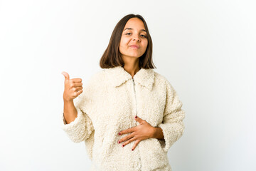 Young mixed race woman touches tummy, smiles gently, eating and satisfaction concept.