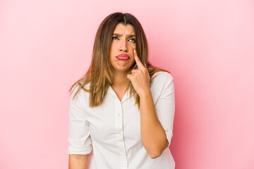 Young indian woman isolated on pink background crying, unhappy with something, agony and confusion concept.