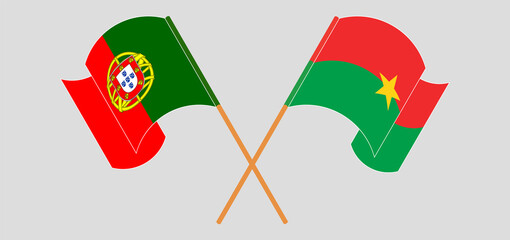 Crossed and waving flags of Portugal and Burkina Faso