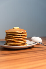 Freshly made hot pancakes accompanied by butter