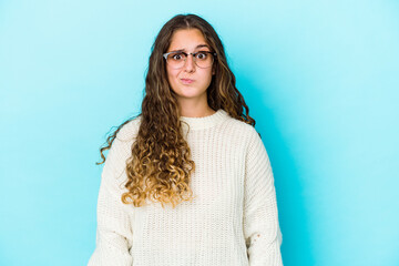 Young caucasian curly hair woman isolated blows cheeks, has tired expression. Facial expression...