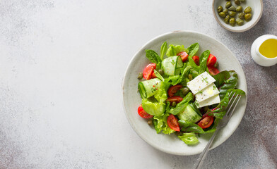 Fresh salad with tomatoes, cucumbers, capers, feta and mixed salad leaves