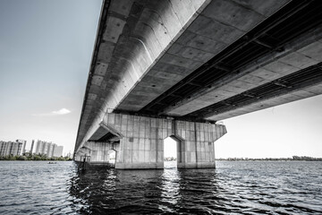 View through the pillars of the bridge. The left bank of the Dnieper in the city of Kiev. Under the bridge. Black and white photo