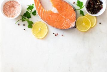 Food stone  background with raw salmon steak, sea salt, peppers and lemon