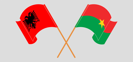 Crossed and waving flags of Albania and Burkina Faso