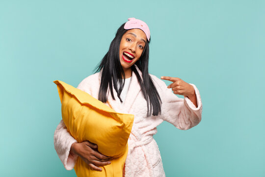 Young Black Woman Looking Excited And Surprised Pointing To The Side And Upwards To Copy Space. Pajamas Concept