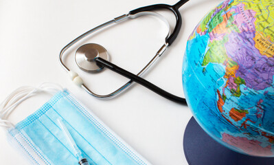 World globe with medical face mask and medical stethoscope