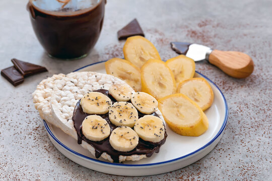 Rice cakes with chocolate spread, banana slice and a sprinkle of chia seeds. - Powered by Adobe