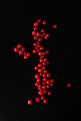 Frozen red currant berries scattered on a black background.