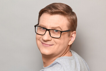 Portrait of happy blond mature man with glasses smiling cheerfully