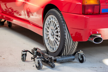 Red car on hidraulic wheel skates for easy moving in the service.