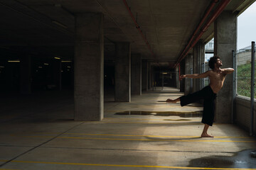 Obraz premium Chico bailando en parking y frente pared roja