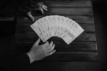 A man laying money on the table, black and white photo