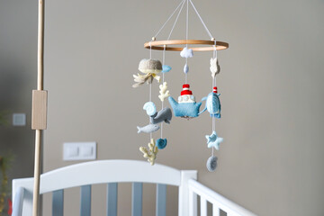 Diy craft baby crib mobile. Toys hang over the crib