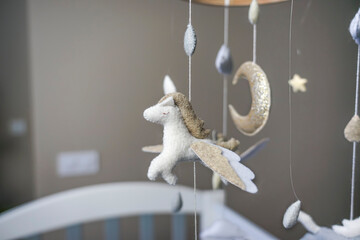 Diy craft baby crib mobile. Toys hang over the crib