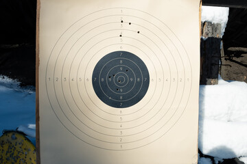 Target with numbers for shooting at a shooting range. A round target with a marked bull's-eye for shooting practice on the shooting range. Target with bullet holes