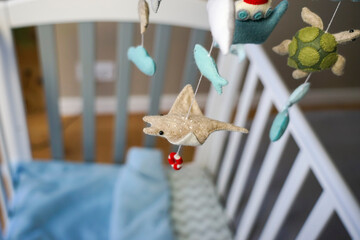 Diy craft baby crib mobile. Toys hang over the crib