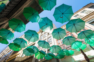 Decorative Green Umbrellas Hanging Between Buildings in the City
