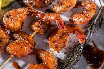 Homemade fried shrimp skewers with garlic, lemon and herbs, top view with selective focus