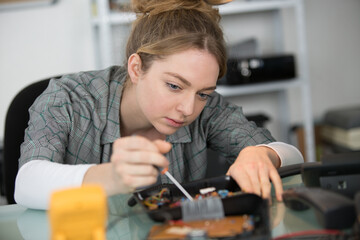 young businesswoman concentrates on fixing a computer