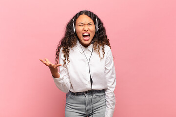 young hispanic woman looking angry, annoyed and frustrated screaming wtf or what’s wrong with...