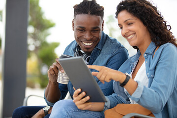 trendy young couple in town using tablet