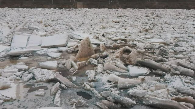 Huge Ice Loads Drift in the River Ogre, Latvia. Aerial Dron Shot in Snowy Mart Day. Congestion on the River in the Spring. A Large Cluster of Moving Ice Blocks