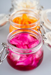 Homemade village fermented sauerkrauts, red cabbage and korean carrot in glass jars, gray background. Concept probiotics food, Supplement for gut health . Adaptogens. Superfood, Close up.