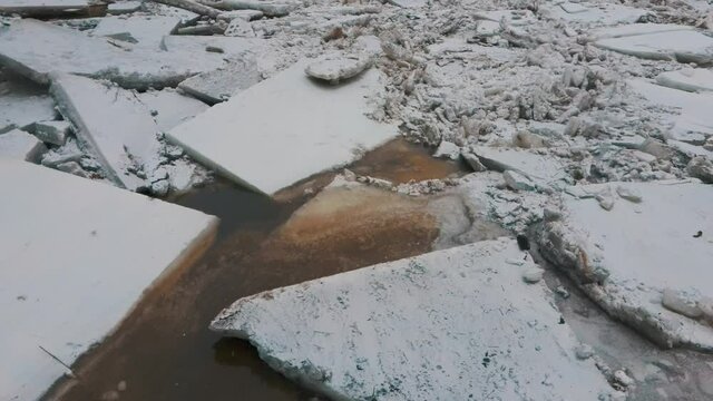 Huge Ice Loads Drift in the River Ogre, Latvia. Aerial Dron Shot in Snowy Mart Day. Congestion on the River in the Spring. A Large Cluster of Moving Ice Blocks