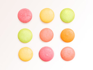 Macaroons Flat lay photo in minimal style  Pink, orange, yellow, and green almond cookies are lying in rows on white background