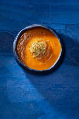 Pumpkin cream with germinated seeds on blue background