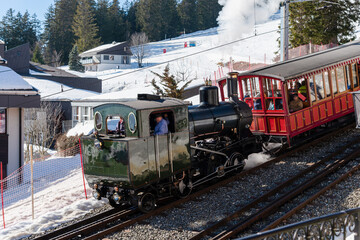 Cogwheel locomotive train operating from lake Lucerne to the top of Rigi alpine ski resort. Historic old vintage cogwheeel steam train in winter on Rigi mountain ski resort, Switzerland