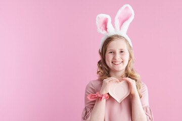 Obraz na płótnie Canvas happy stylish child with long wavy blond hair on pink